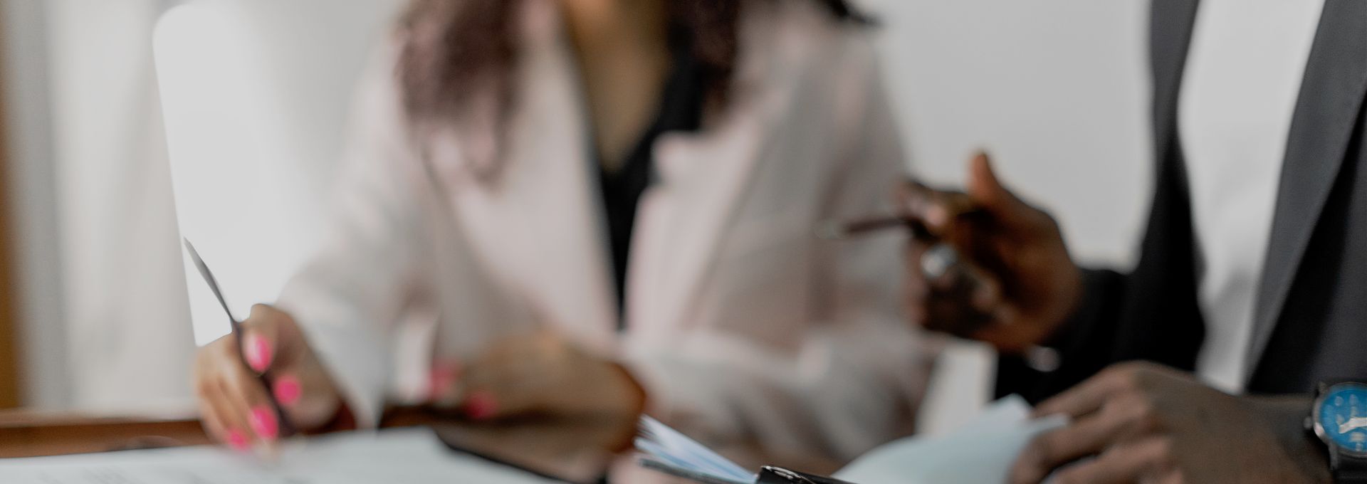 Deux personnes remplissent et signent un dossier administratif